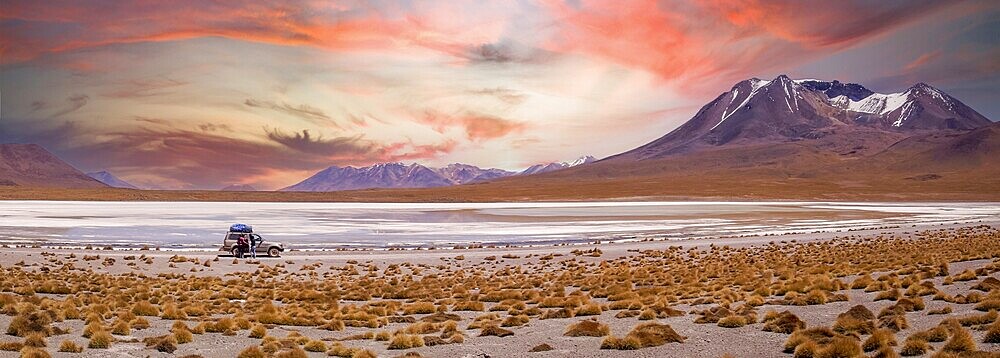 Amazing sky at sunset over Altiplano, Bolivia as an off-road vehicle is driving by