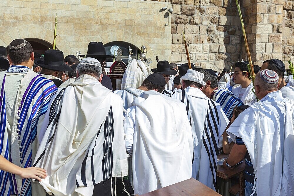 JERUSALEM, ISRAEL - OCTOBER 12, 2014: Morning autumn Sukkot. The area in front of Western Wall of Temple filled with people. Crowd of faithful Jews wearing prayer shawls
