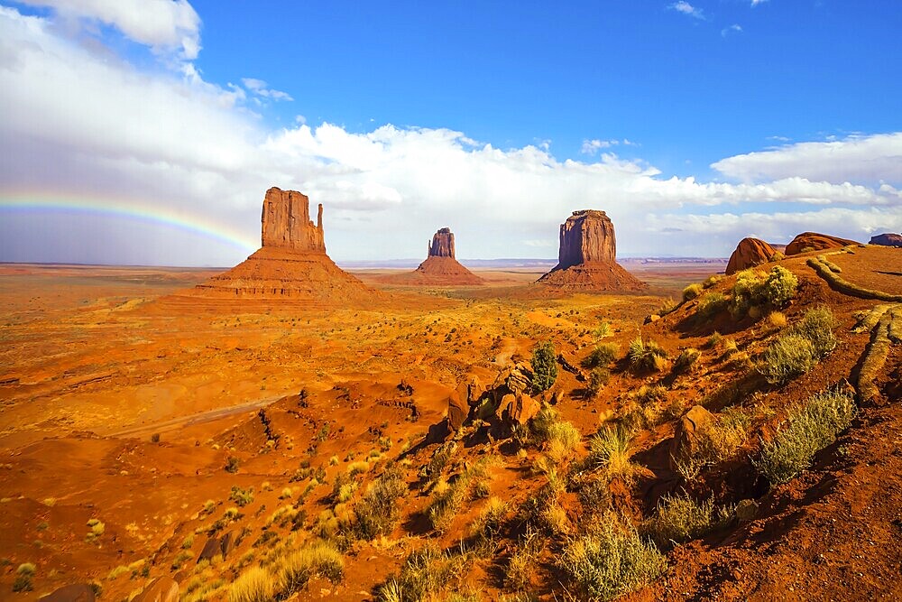 The USA. Magnificent rainbow across the sky. Monument Valley is unique geological formation. Huge masses of red sandstone - outliers on the Indian Navajo Reservation. Concept of photo tourism
