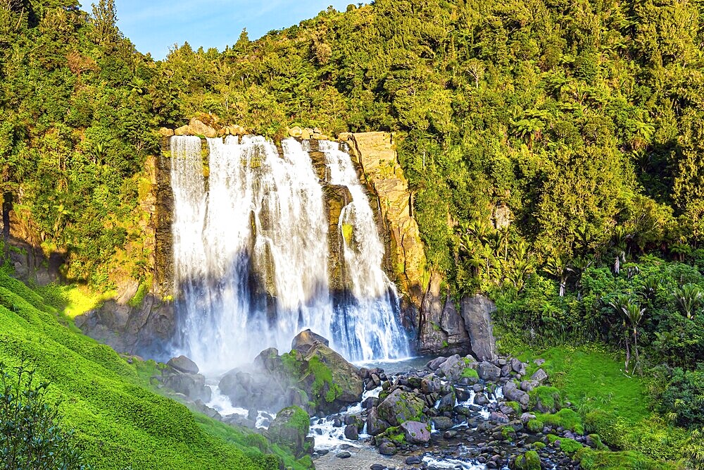 North Island. The largest and widest waterfall in Marocopa. The setting sun illuminates the stormy and thundering jets of water and snow-white foam. The magical beauty of New Zealand