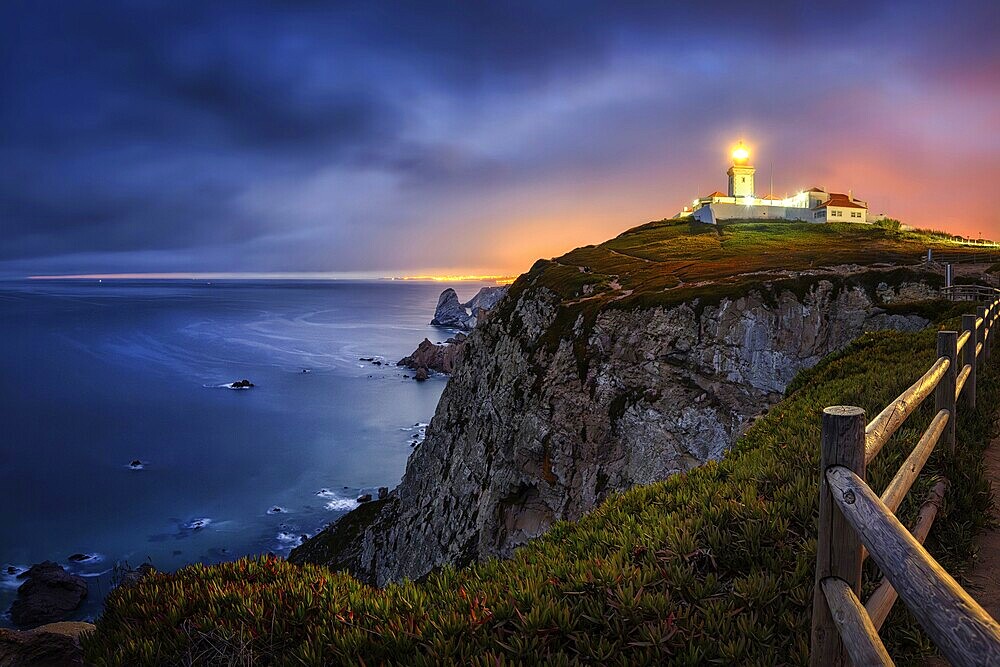 Farol do Cabo de Boca, Portuguese coast with a lit lighthouse at night