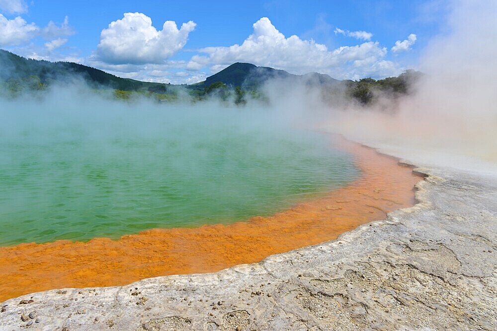 Bubbling mineral spring with steam and surrounded by mountains, Champagne Pool thermal lake, Wai-O-Tapu Thermal Wonderland, Rotorua, North Island, New Zealand, Oceania