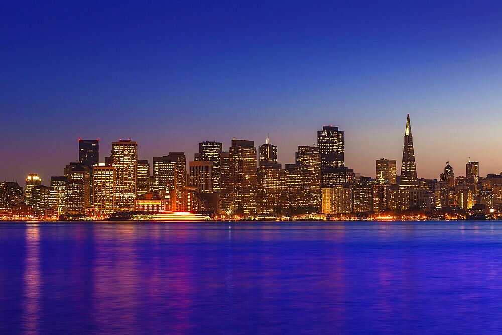 San Francisco sunset skyline in California with reflection in bay water USA