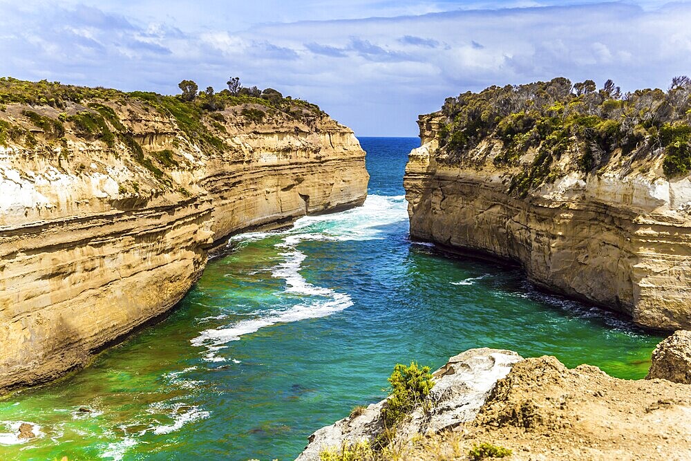 The Great Ocean Road of Australia. Coastal rocks are composed of sandstone. Small ocean fjord with clear green water. The concept of exotic, active and photo-tourism