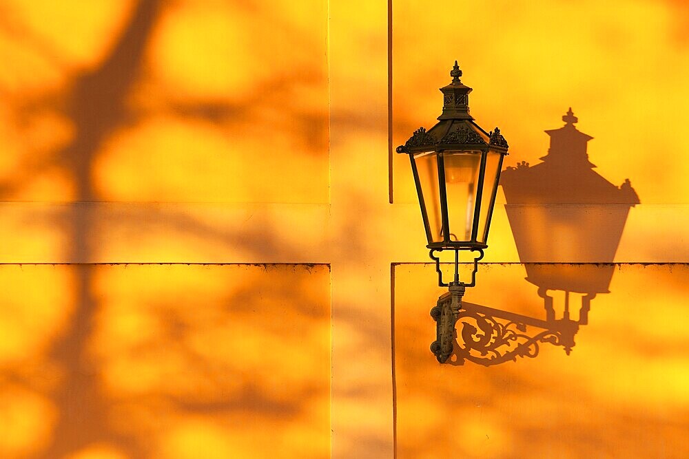Detail of retro street light on the wall at sunset. Prague, Czech Republic