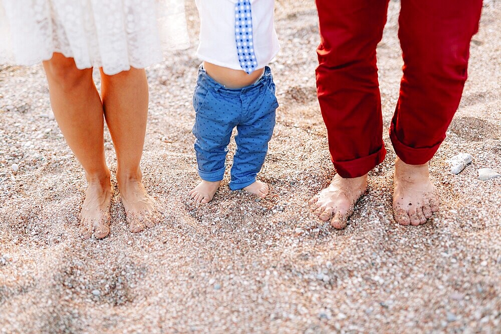 Family legs on the beach. Parents with children on the beach. Family holidays in Montenegro