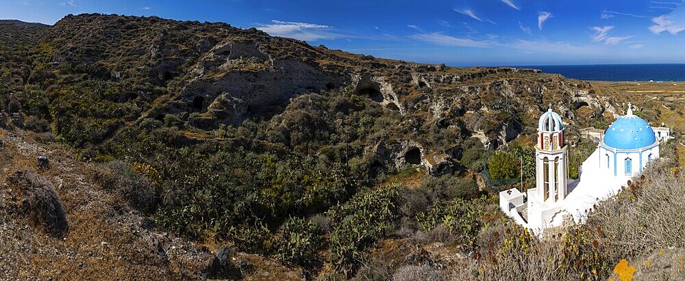 Monastery church of Panagia Agrilia, abandoned cave dwellings in erosion valley, panoramic view, island of Thirassia, archipelago of Santorini, Cyclades, Greece