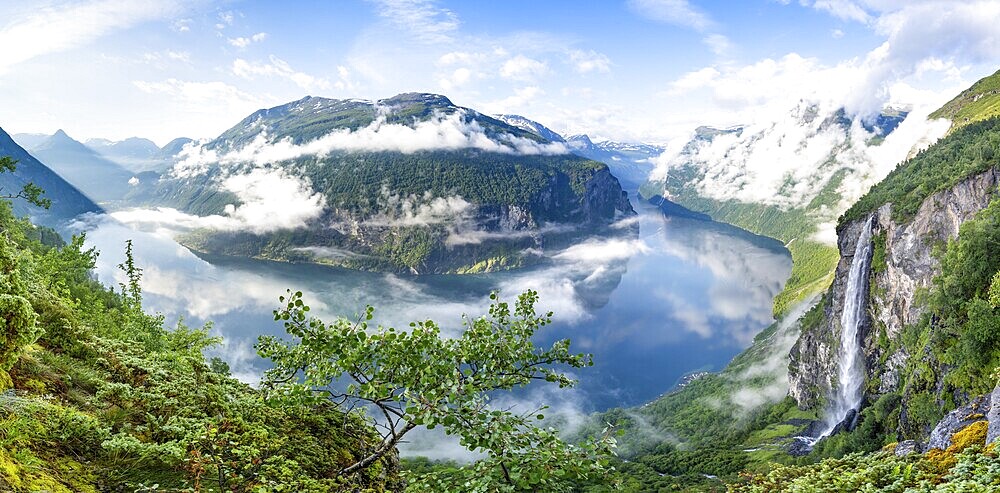 Panoramic view, Gjerdefossen waterfall, at Ørnesvingen viewpoint, atmospheric clouds over the fjord in the morning light, at Geirangerfjord, near Geiranger, Møre og Romsdal, Norway