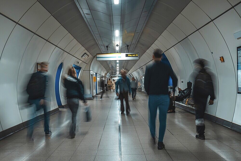 Tourists and commuters navigating an underground corridor in London, united kingdom, surrounded by modern architecture and vibrant energy