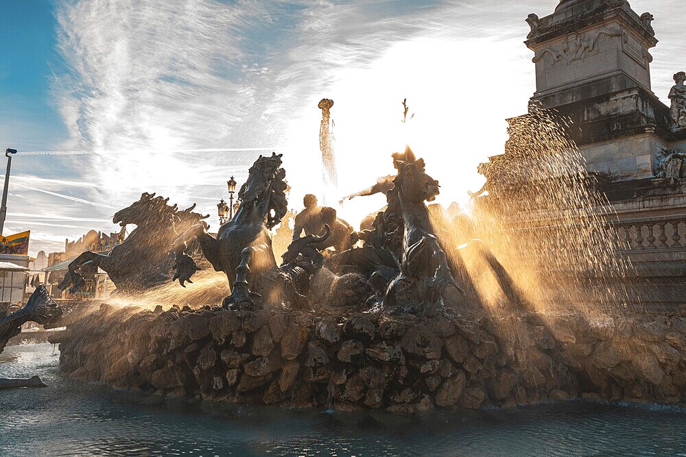 The majestic monument aux girondins fountain, located in place des quinconces, bordeaux, is illuminated by the golden rays of the setting sun