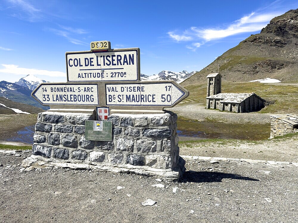 In the foreground signpost to the pass summit of the highest navigable alpine pass Col de l'Iseran 2764 2770 metres high, Iseran Pass, Iseran, below direction signs to Lanslebourg and Bourg Saint Maurice, in the background chapel Chapelle Notre-Dame-de-Toute-Prudence, Col de l'Iseran, departmental road D902, Route des Grandes Alpes, Département Savoie, Region Auvergne-Rhône-Alpes, Graian Alps, France