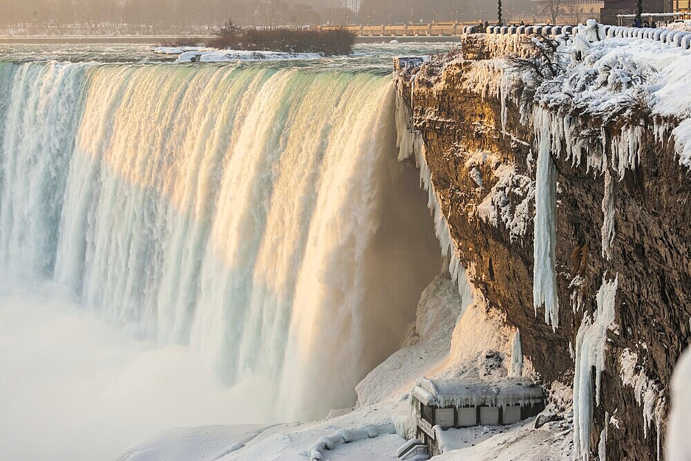The Canadian Horseshoe Falls in on a cold winters day with snow and ice covering the railings and walkway in Niagara Falls, Ontario, Canada, North America