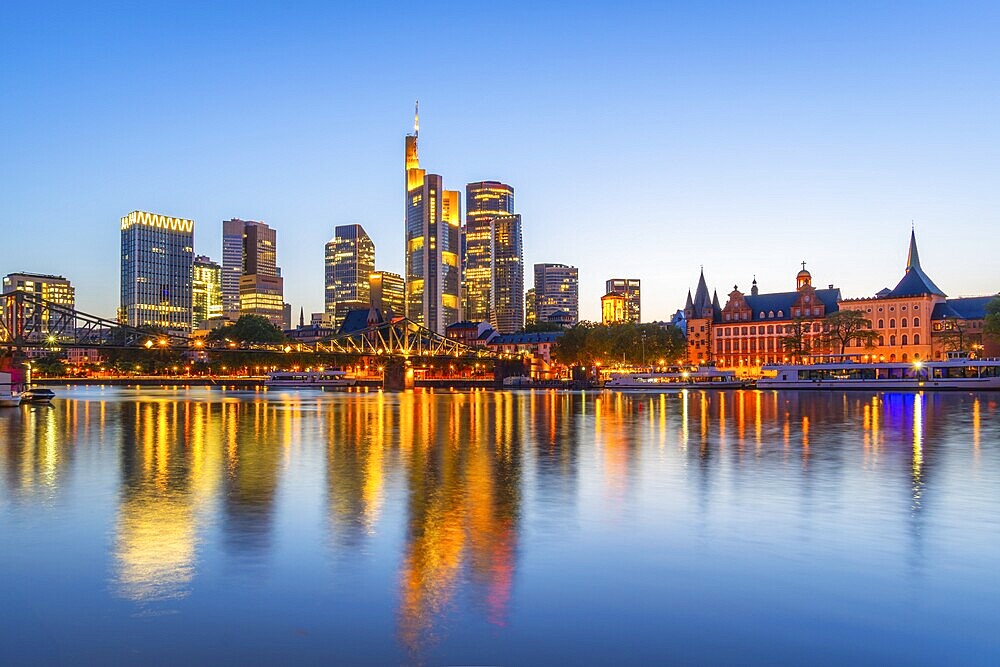 Illuminated Frankfurt City Downtown Skyscrapers at Evening Twilight and Reflection in Main River. Blue Hour. Hesse, Germany