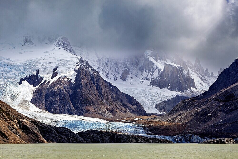 Dramatic glacier with rocks and threatening clouds form an impressive backdrop, The Perito Moreno glacier in Argentina