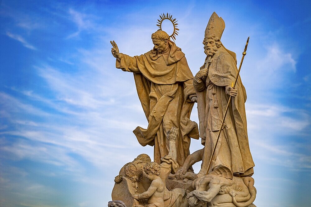 Sculpture of saints under a blue sky, symbolic and majestic, Charles Bridge, Prague, Czech Republic