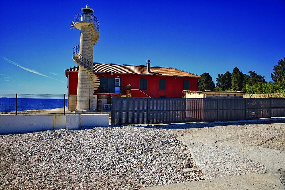 Red house with lighthouse by the sea under a clear blue sky, Mediterranean atmosphere, lighthouse Zadar, Central Dalmatia, Croatia