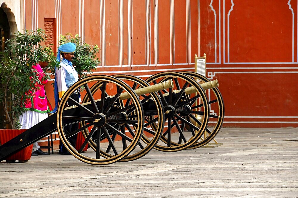 City Palace Jaipur, Rajasthan, North India, India, Asia, Two cannons in front of a red wall with traditionally dressed people