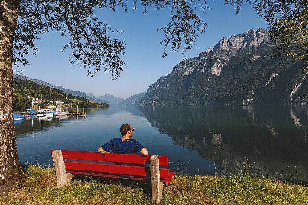 Sitting, red bench, lake, morning sun, Switzerland