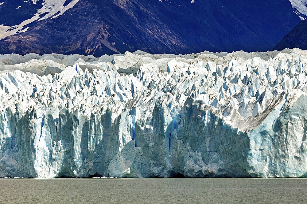 Detailed view of a massive blue glacier against a mountain backdrop, The Perito Moreno glacier in Argentina