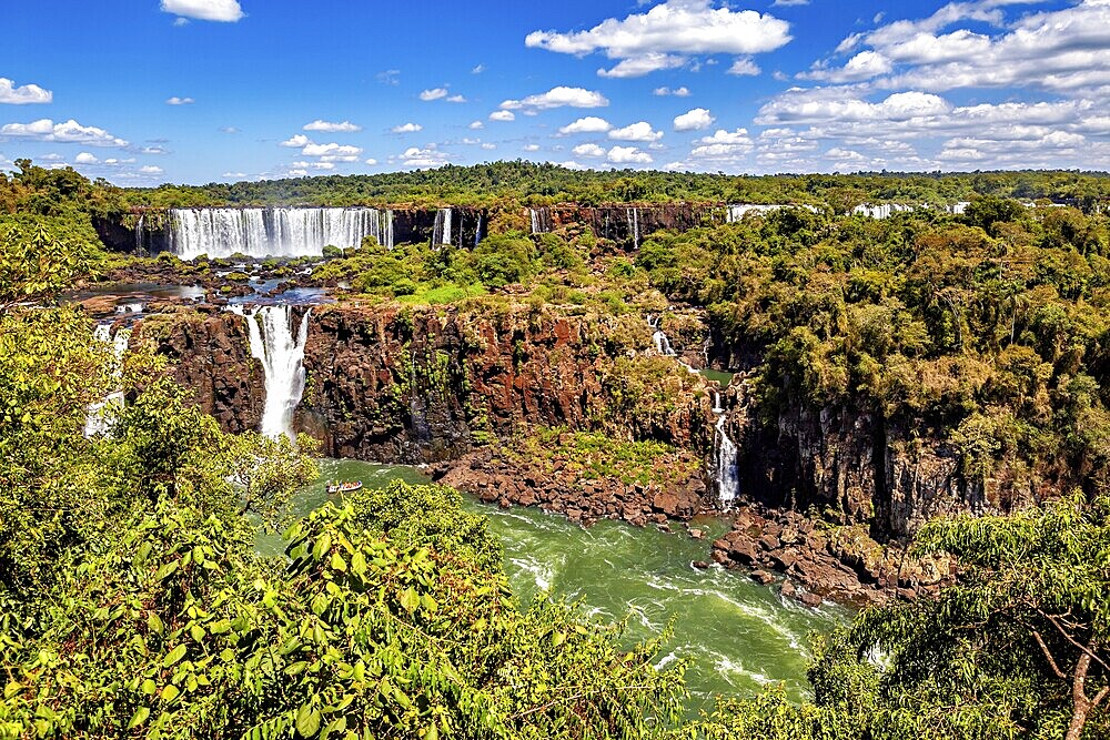 Impressive waterfalls with lush natural scenery under a bright blue sky, The Iguazu Falls between Argentina and Brazil