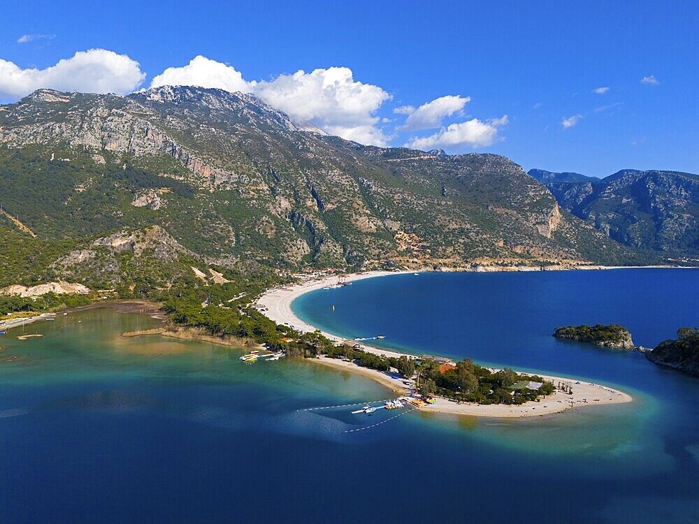View of a beach with a peninsula surrounded by mountains and blue sea under a clear sky with clouds, aerial view, Fethiye, Muğla, Mugla, Aegean Sea, Turkey
