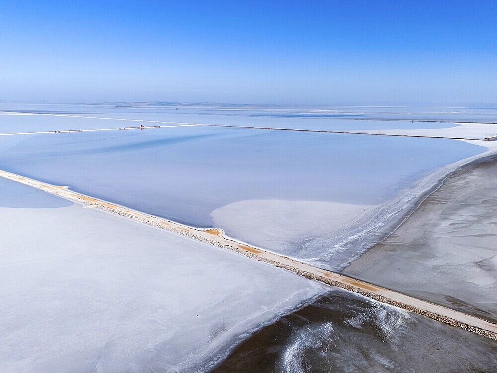 A vast salt lake under a clear blue sky, with simple geometric lines and footbridge, aerial view, salt lake, Tuz Gölü, location between Konya, Aksaray and Ankara, Turkey