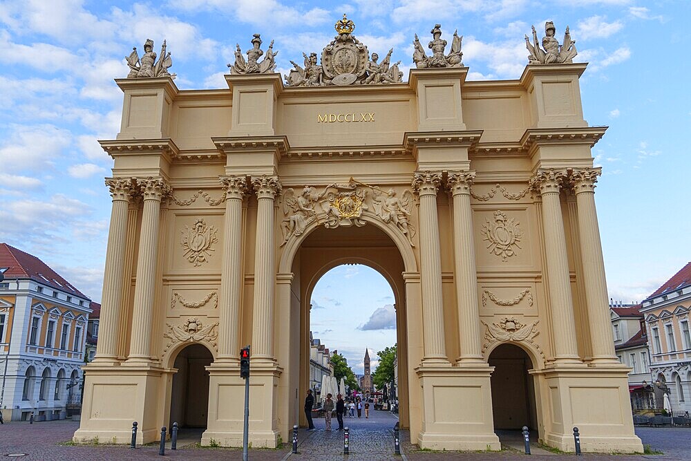 Impressive baroque triumphal arch under a blue sky with detailed reliefs and decorations, potsdam, brandenburg, germany
