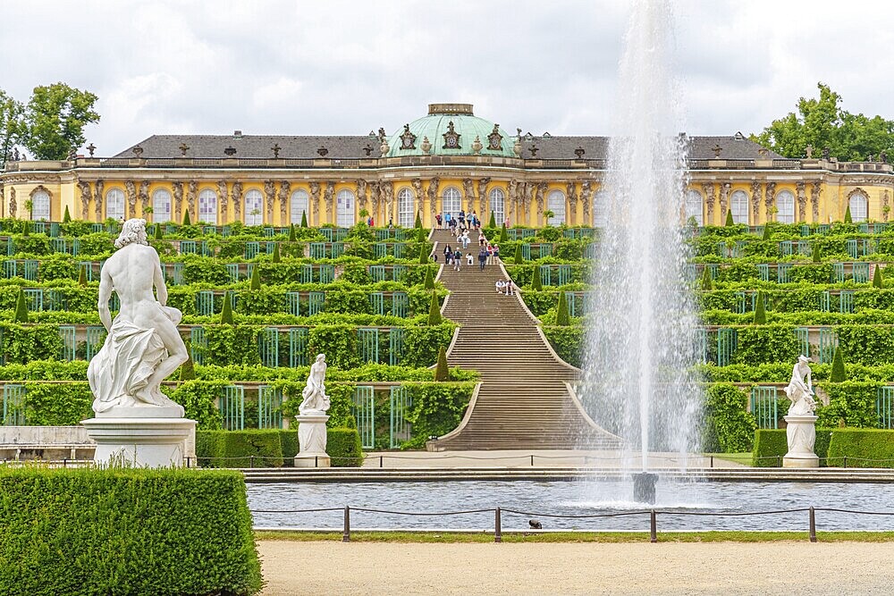 Symmetrical view with fountain in front of Sanssouci, flanked by sculptures, potsdam, brandenburg, germany