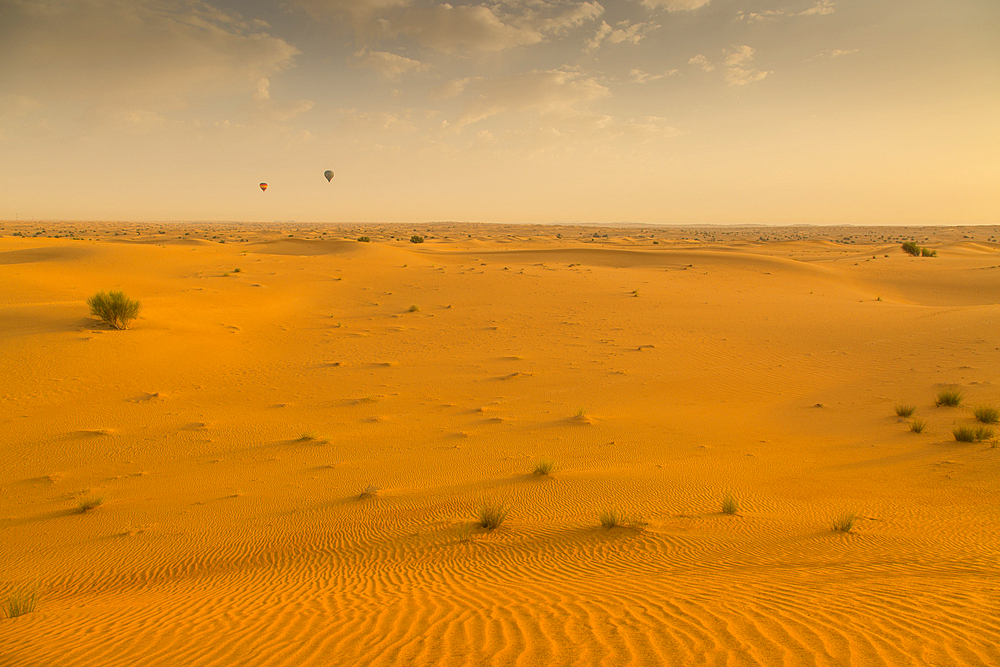 Hot air balloons over sand dunes at sunrise in the Dubai Desert, Dubai, United Arab Emirates, Middle East