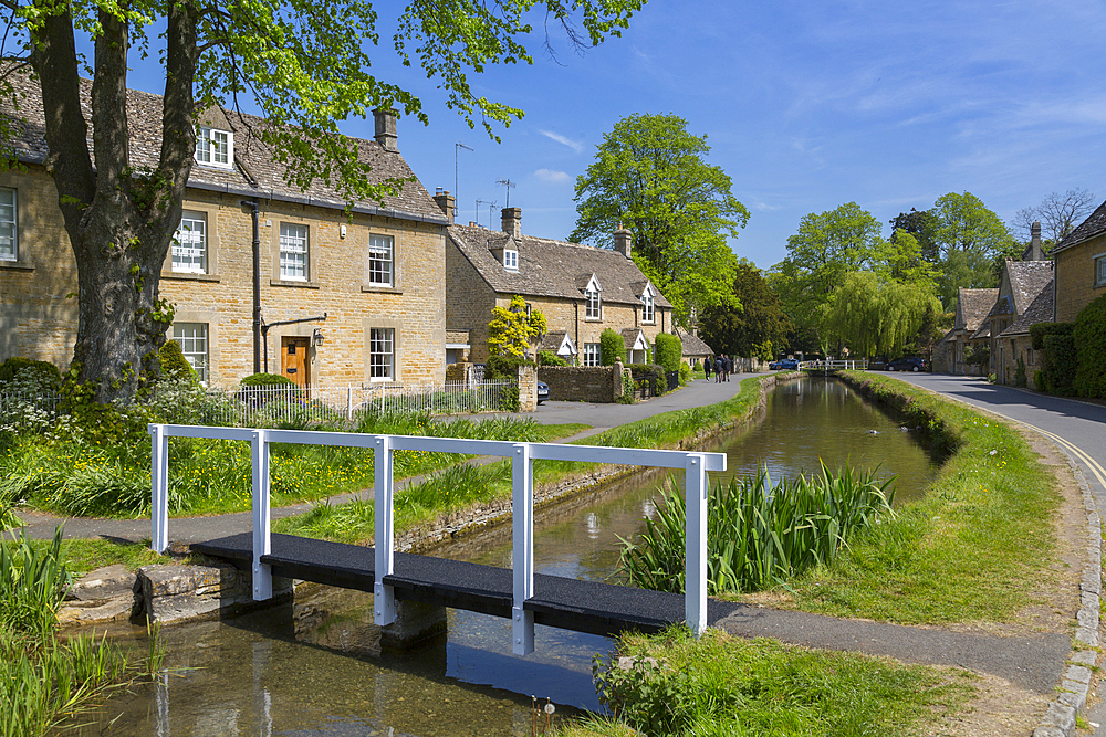 Cottages and footbridge over the River Eye in Lower Slaughter, Cotswolds, Gloucestershire, England, United Kingdom, Europe