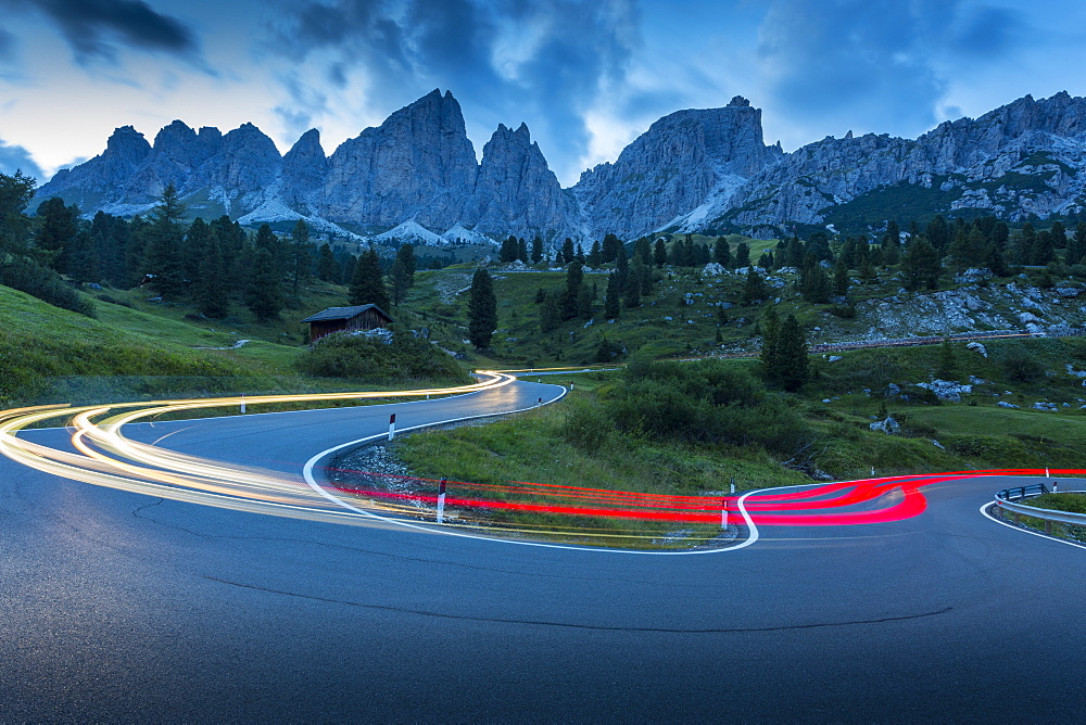 Car trail lights on Passo Pordoi with mountain backdrop at dusk, Province of Bolzano, South Tyrol, Italian Dolomites, Italy, Europe