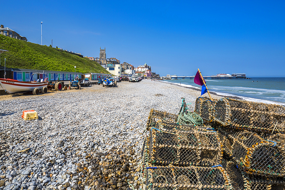 View of fishing baskets on the beach and Parish Church overlooking pier on a summer day, Cromer, Norfolk, England, United Kingdom, Europe