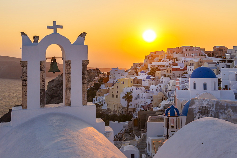 View of traditional blue domed churches and white houses at sunset in Oia, Santorini, Cyclades, Aegean Islands, Greek Islands, Greece, Europe