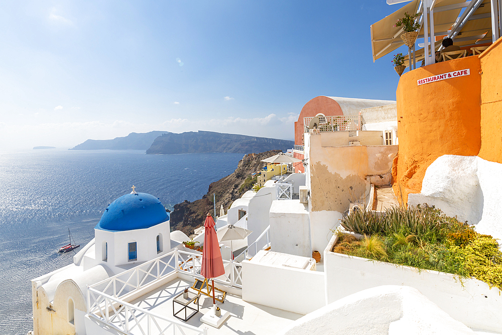 View of blue domed church from cafe in Oia village, Santorini, Cyclades, Aegean Islands, Greek Islands, Greece, Europe