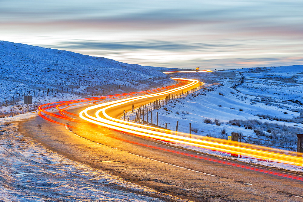 View of trail lights on frozen landscape near Buxton at dusk, High Peak, Derbyshire, England, United Kingdom, Europe