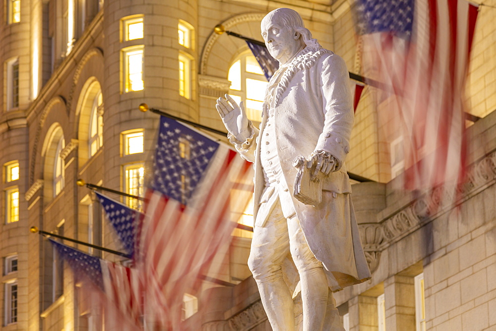 View of Benjamin Franklin statue and US flags in front of former Old Post Office Pavilion, Washington D.C., United States of America, North America