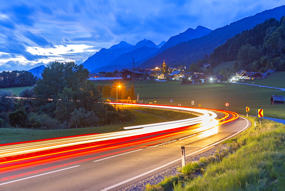 View of winding road and trail lights at dusk near Oberhaus, Styria, Austria, Europe