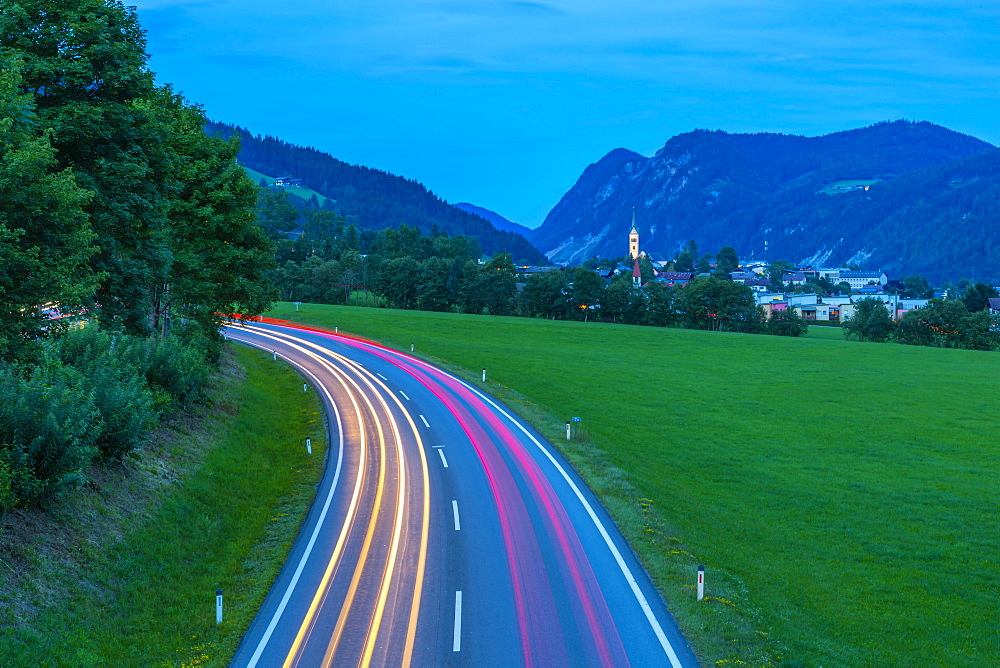 Trail lights and illuminated church in Radstadt at dusk, Radstadt, Styria, Austria, Europe