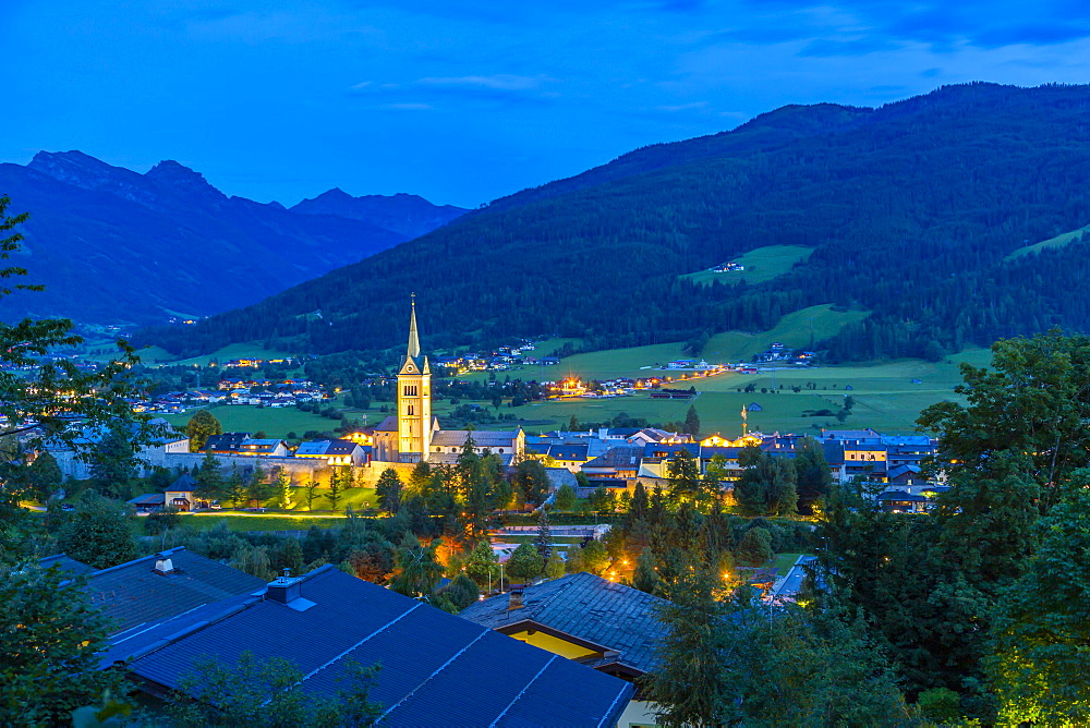 View of illuminated church in Radstadt at dusk, Radstadt, Styria, Austria, Europe