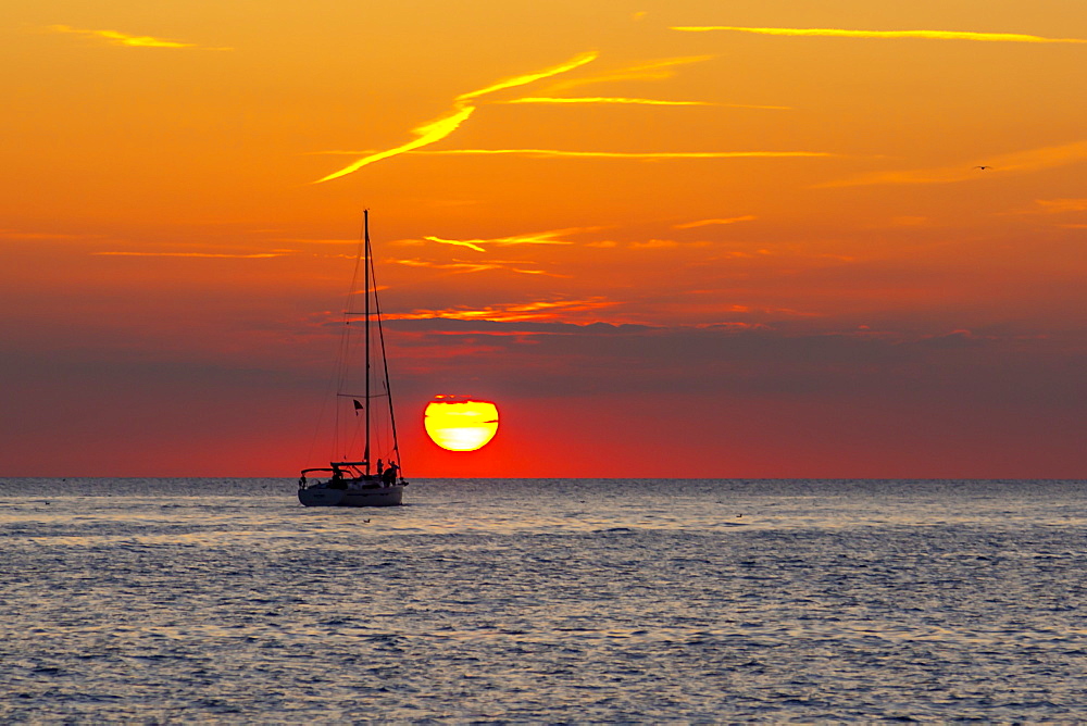 View of sunset and sailboat on Adriatic Sea from the old town, Rovinj, Istria, Croatia, Adriatic, Europe