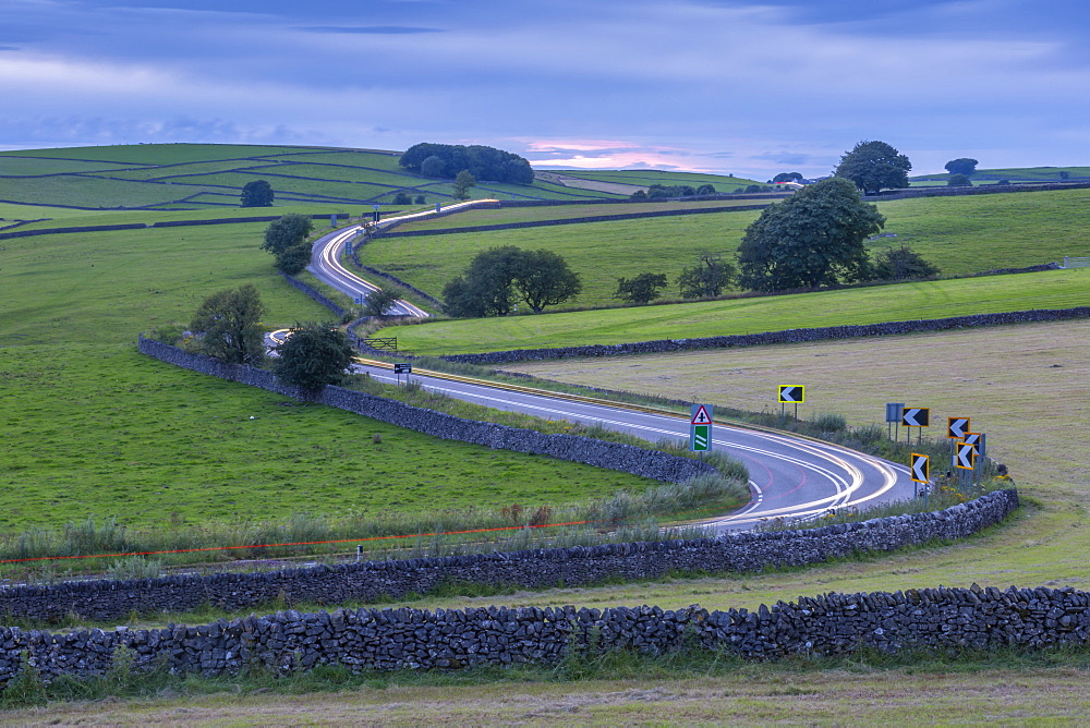 View of trail lights on winding road near Tideswell, Peak District National Park, Derbyshire, England, United Kingdom, Europe