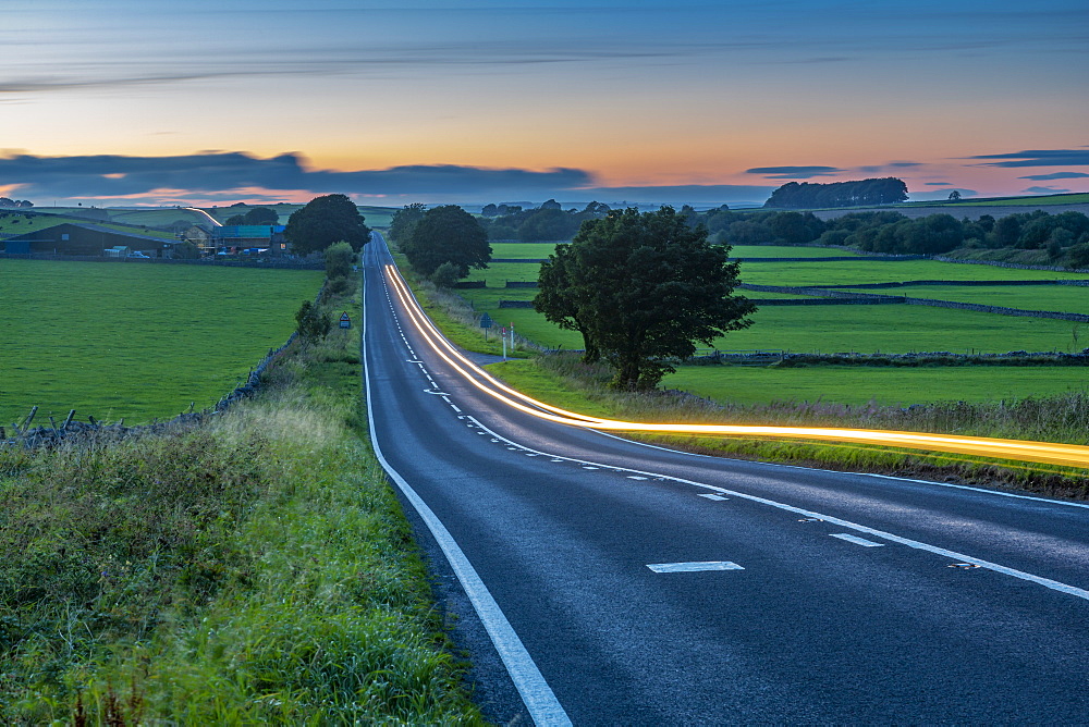 View of trail lights on the A515 near Newhaven at dusk, Peak District National Park, Derbyshire, England, United Kingdom, Europe