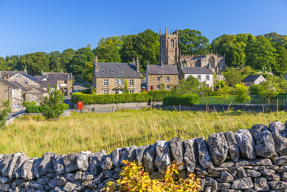 View of village church and dry stone walls, Hartington, Peak District National Park, Derbyshire, England, United Kingdom, Europe