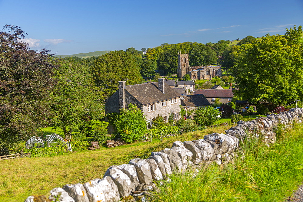 View of village church and dry stone walls, Hartington, Peak District National Park, Derbyshire, England, United Kingdom, Europe