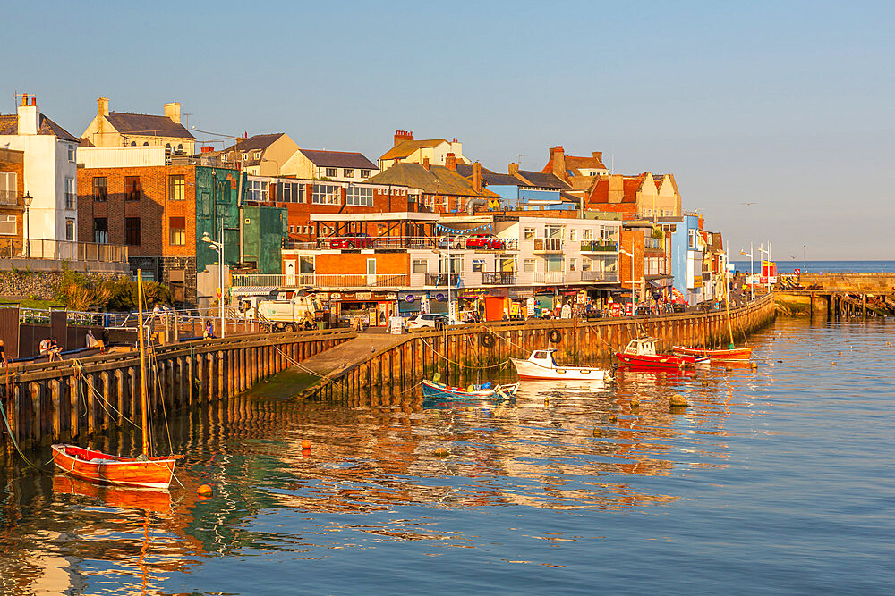 View of harbour boats and harbourside shops in Bridlington Harbour at sunset, Bridlington, East Yorkshire, England, United Kingdom, Europe