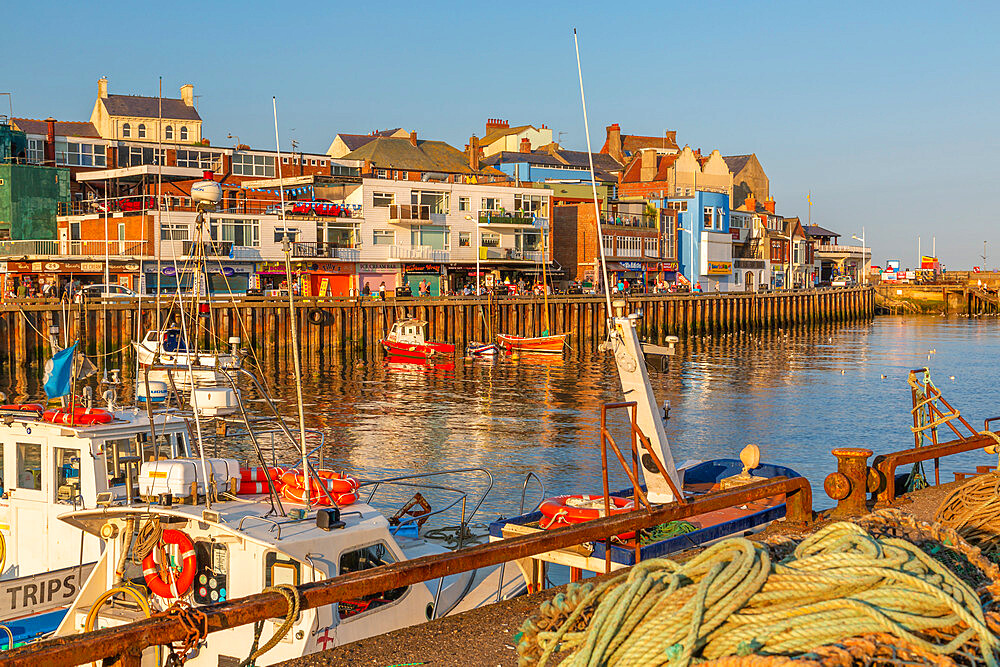 View of harbour boats and harbourside shops in Bridlington Harbour at sunset, Bridlington, East Yorkshire, England, United Kingdom, Europe