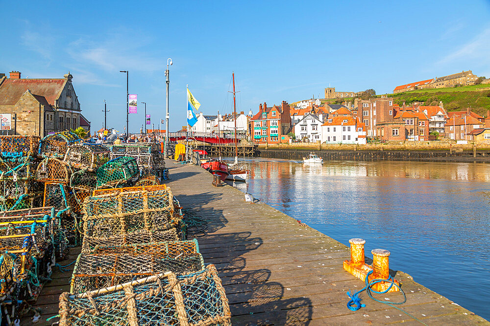 View of St. Mary's Church and fishing baskets, houses and boat on the River Esk, Whitby, Yorkshire, England, United Kingdom, Europe