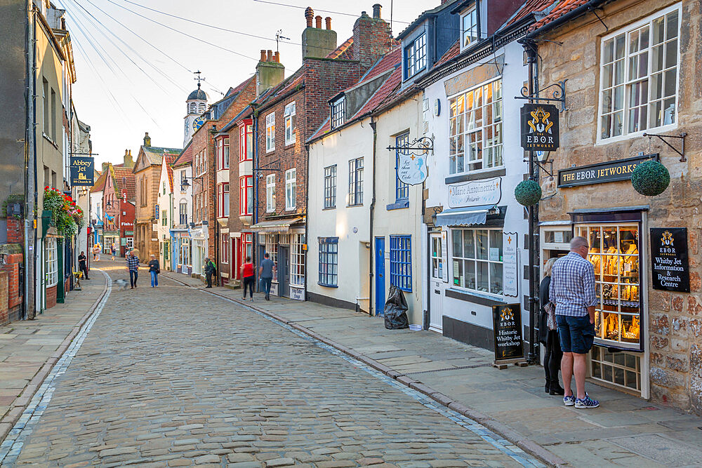 View of shops on traditional cobbled street in historic town centre, Whitby, Yorkshire, England, United Kingdom, Europe