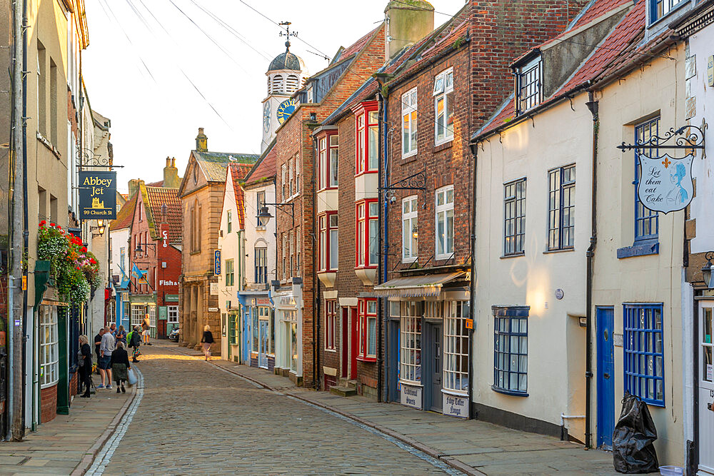 View of shops on traditional cobbled street in historic town centre, Whitby, Yorkshire, England, United Kingdom, Europe