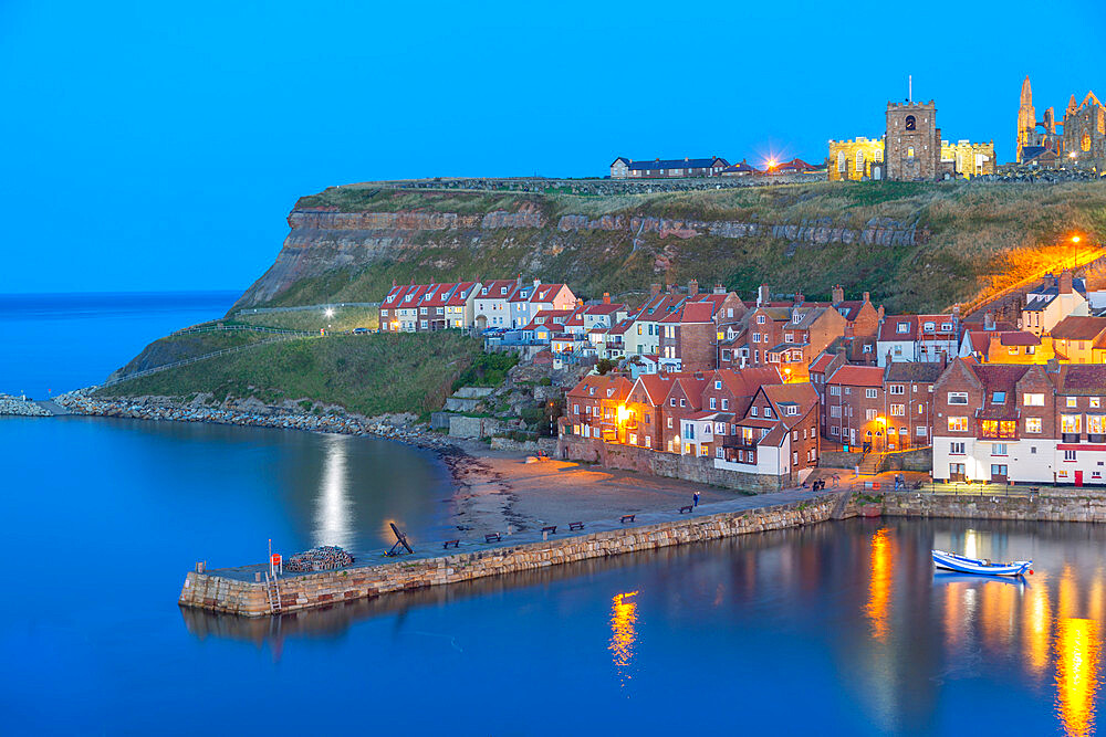 View of St. Mary's Church and Whitby Abbey from across River Esk at dusk, Whitby, Yorkshire, England, United Kingdom, Europe